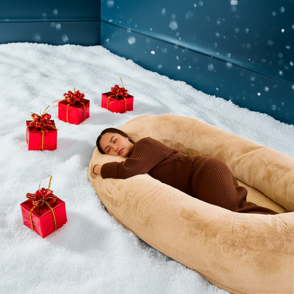 Person lying in a beige bean bag with red gift boxes and snow around